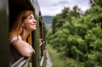 female-tourist-traveling-in-train-standing-out-of-window-train-and-looking-beautiful-nature-stockpack-istock.jpg