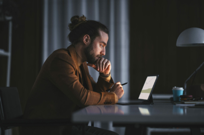 side-view-of-serious-thoughtful-adult-bearded-male-in-stylish-wear-sitting-at-table-with-modern-laptop-and-analyzing-business-information-while-working-in-office-in-late-evening-stockpack-istock.jpg