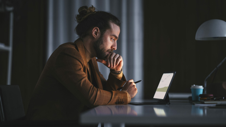 side-view-of-serious-thoughtful-adult-bearded-male-in-stylish-wear-sitting-at-table-with-modern-laptop-and-analyzing-business-information-while-working-in-office-in-late-evening-stockpack-istock.jpg